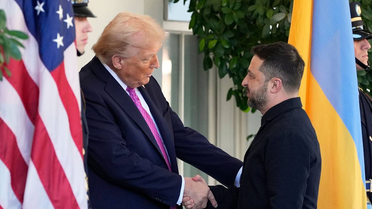 Zwei Männer geben sich die Hand, rechts die ukrainische, links die amerikanische Flagge.