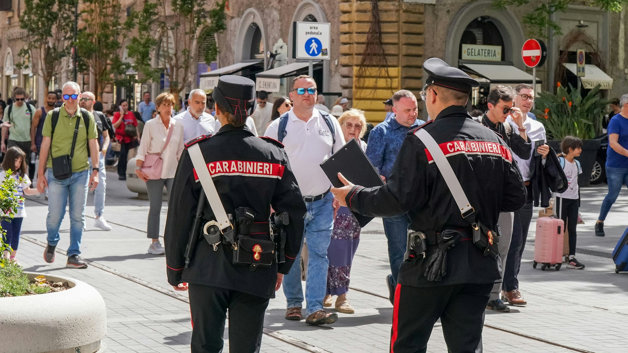 Italienische Polizei (Carabinieri) im Einsatz, zwei Polizisten sprechen auf belebter Straße