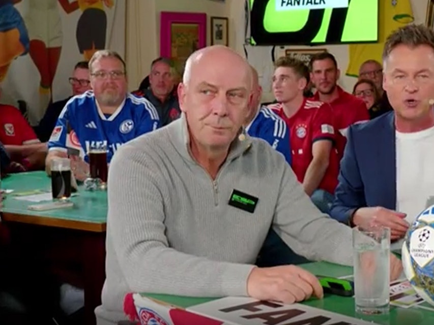 Mario Basler sitzt mit genervter Miene am Tisch des Sport1-Fantalks.