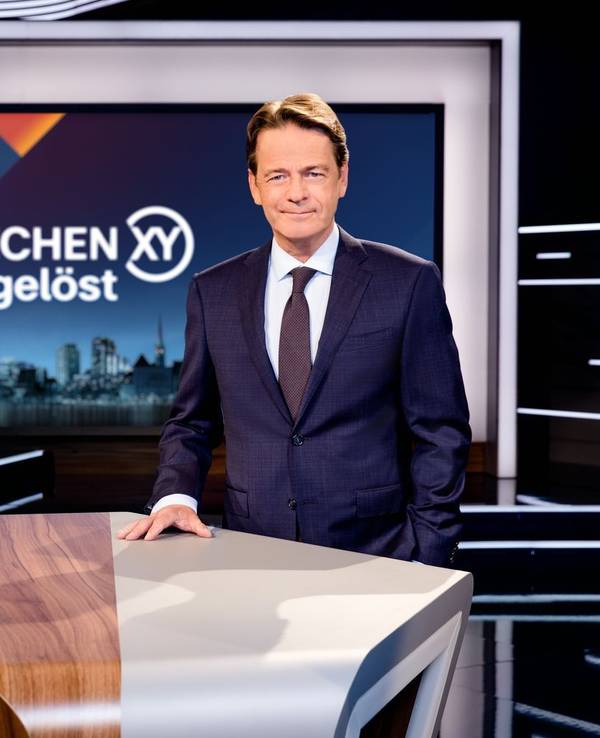 Moderator Rudi Cerne steht in der „Aktenzeichen XY ... ungelöst“-Kulisse.