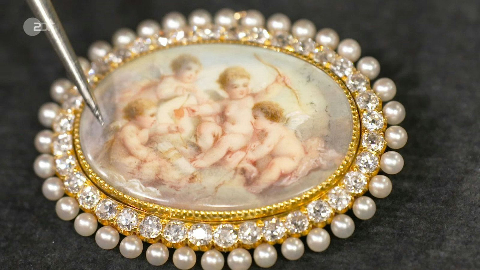 Eine goldene Brosche mit Amor-Motiv und 1,8 Karat Diamanten wollte Frank für 800 Euro veräußern. Bis zu 1.500 Euro hielt Dr. Heide Rezepa-Zabel für realistisch. Susanne Steiger verliebte sich in den Schmuck wie von Amors Pfeil getroffen und bezahlte 1.200 Euro. (Bild: ZDF)