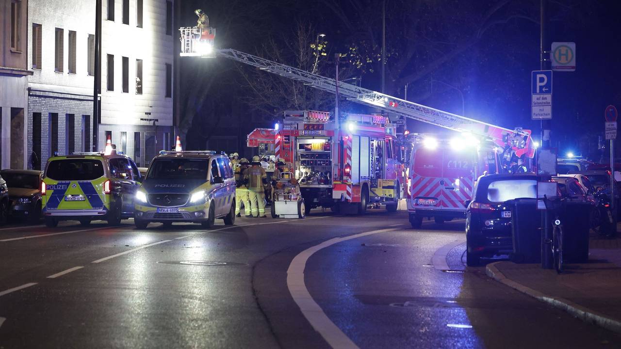 Rettungskräfte arbeiten an einer Fassade eines Mehrfamilienhauses, die nach einer Explosion beschädigt wurde.