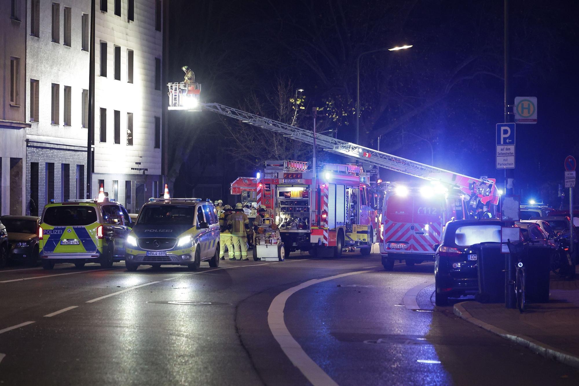 Rettungskräfte arbeiten an einer Fassade eines Mehrfamilienhauses, die nach einer Explosion beschädigt wurde.