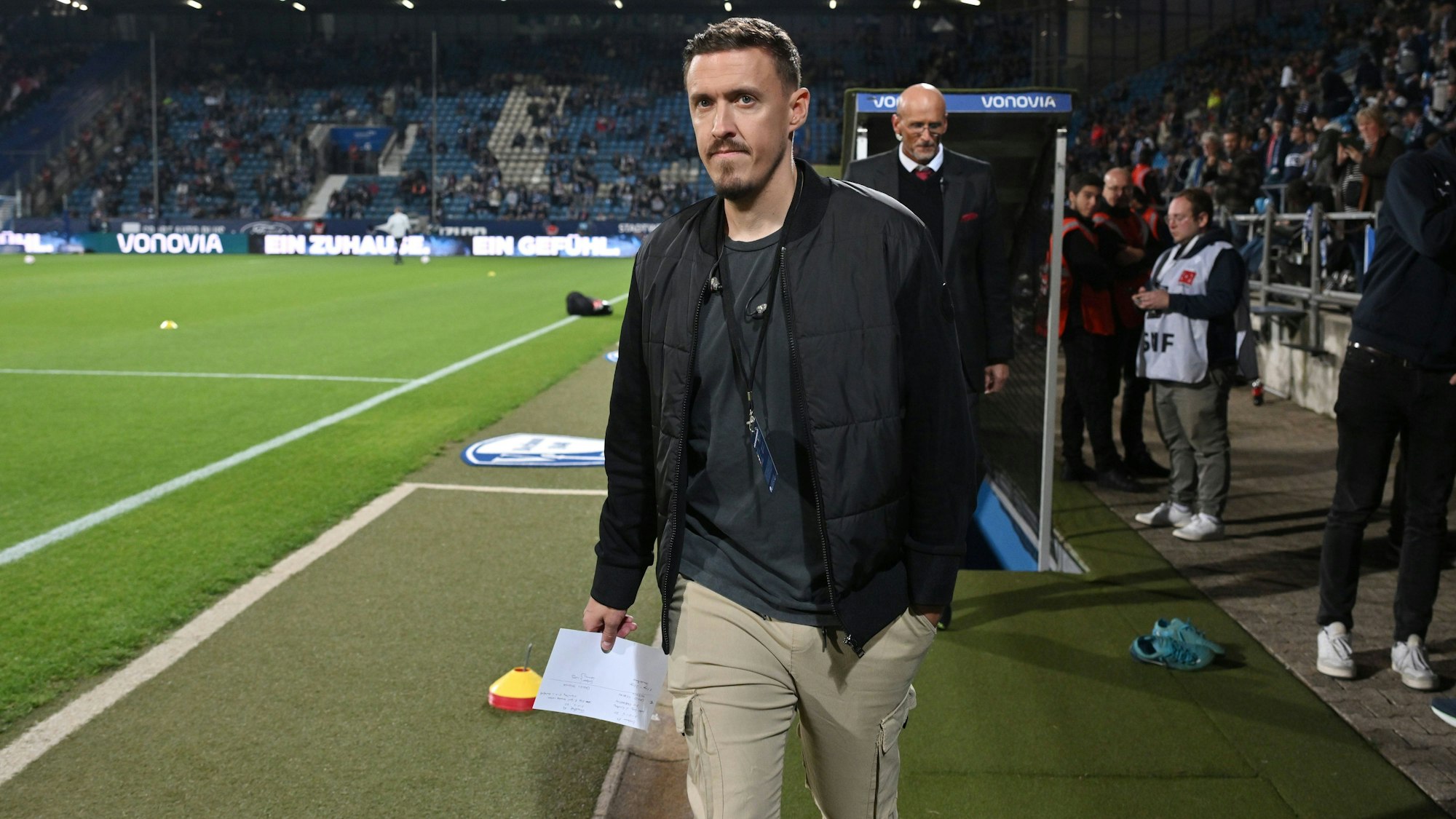 Max Kruse geht in einem Fußballstadion am Spielfeldrand entlang, Zuschauer im Hintergrund.