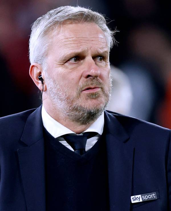 Dietmaer Hamann steht mit Anzug und Krawatte als Experte im Stadion.
