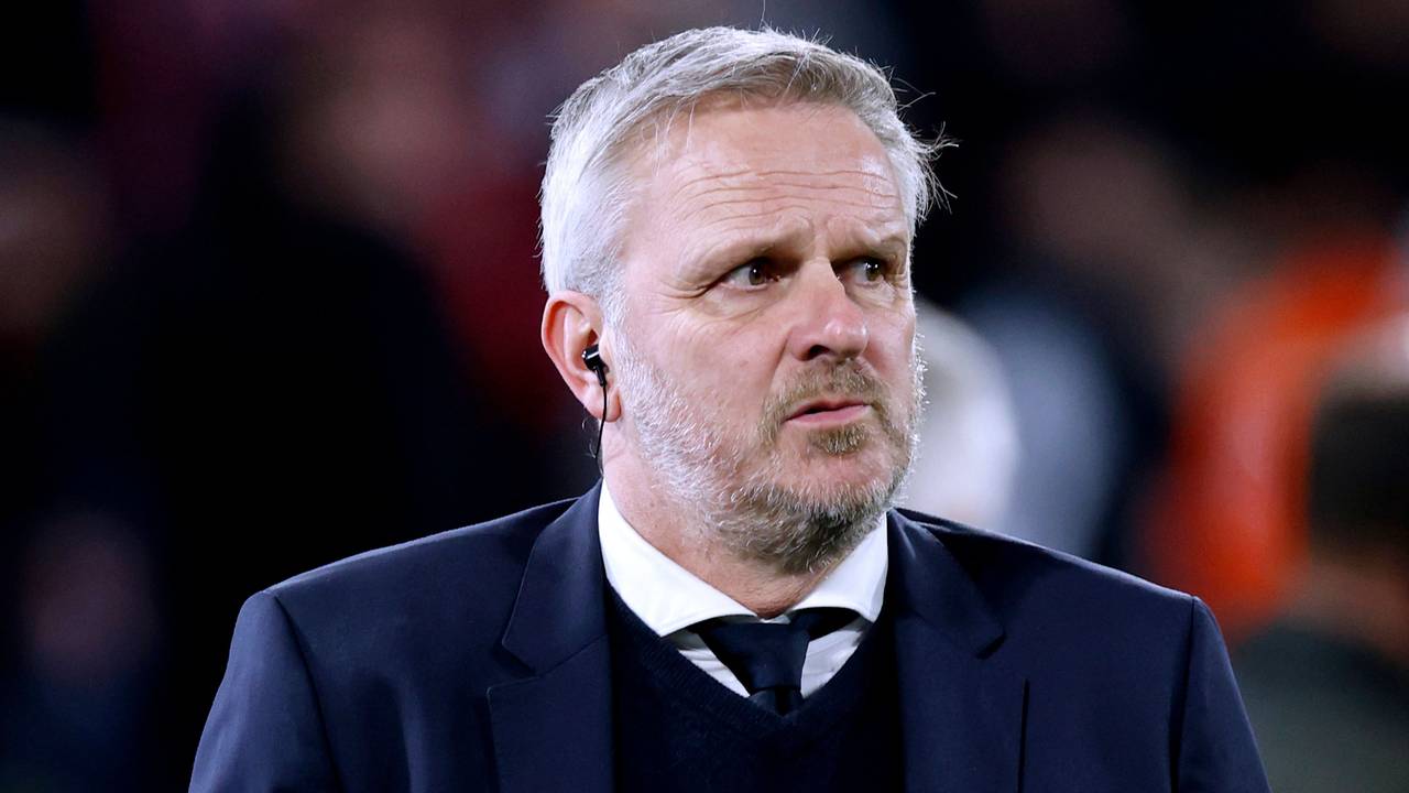 Dietmaer Hamann steht mit Anzug und Krawatte als Experte im Stadion.