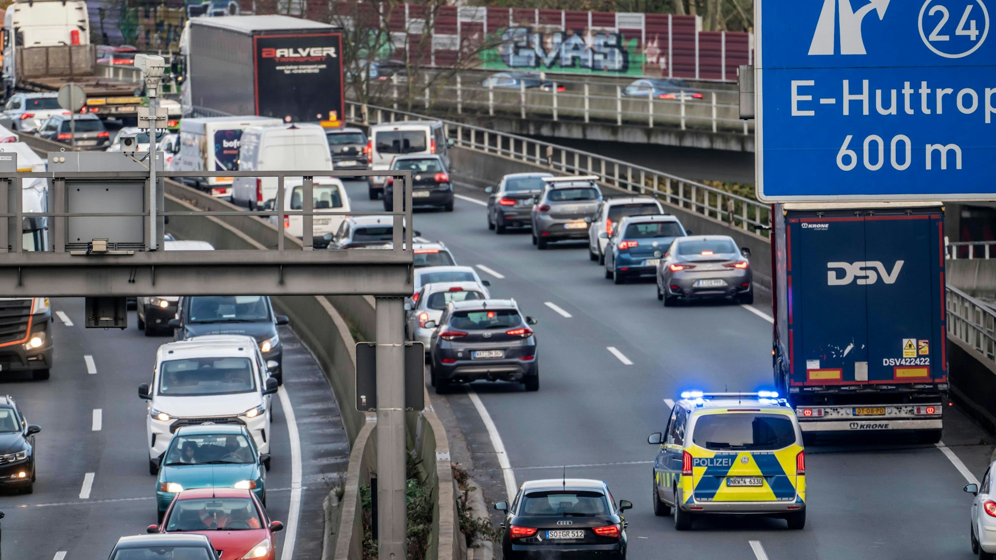 Blick auf eine vielbefahrene Autobahn mit Stau, zahlreichen Fahrzeugen und einem Polizeiauto