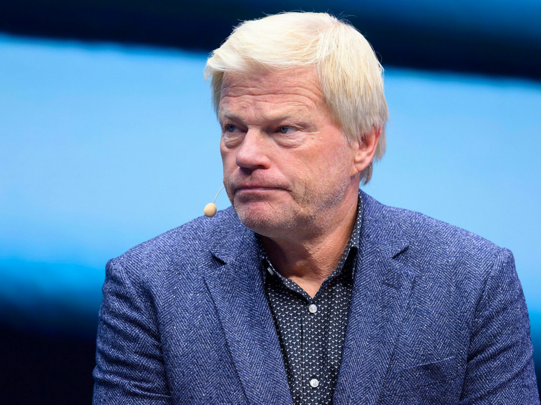 Oliver Kahn sitzt bei einem Interview auf einer Bühne.