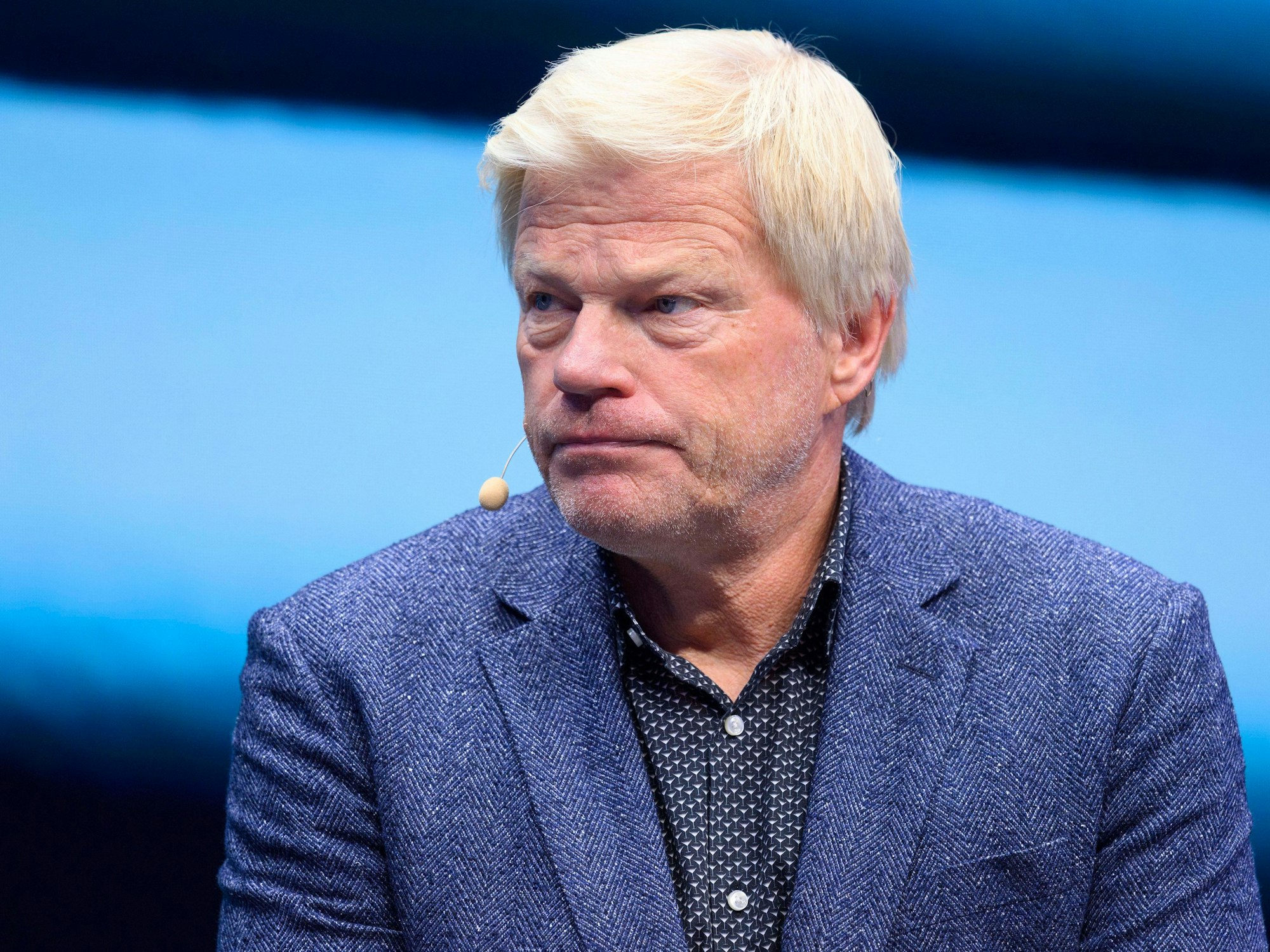 Oliver Kahn sitzt bei einem Interview auf einer Bühne.