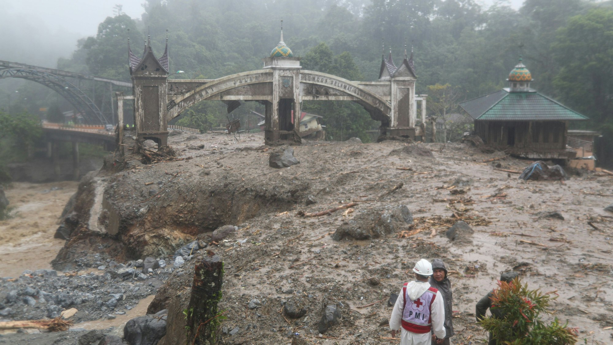 Indonesische Landschaft nach einer Flut: Schlamm, Trümmer, beschädigte Gebäude, Helfer im Einsatz