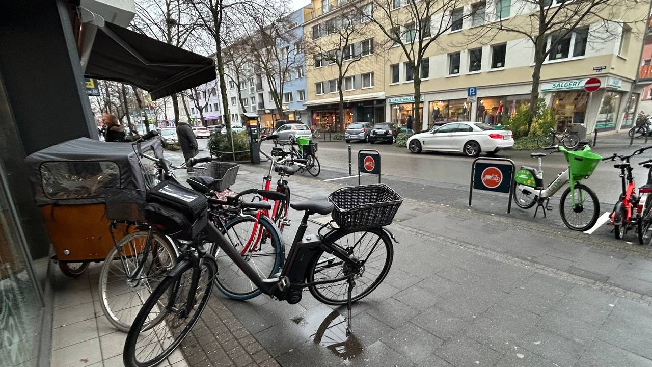 Tägliche Situation auf der Dürener Straße: Vor einem Supermarkt wurde extra ein Lastenfahrrad-Parkplatz errichtet. Genutzt wird er aber nur selten. In diesem Fall gar nicht.