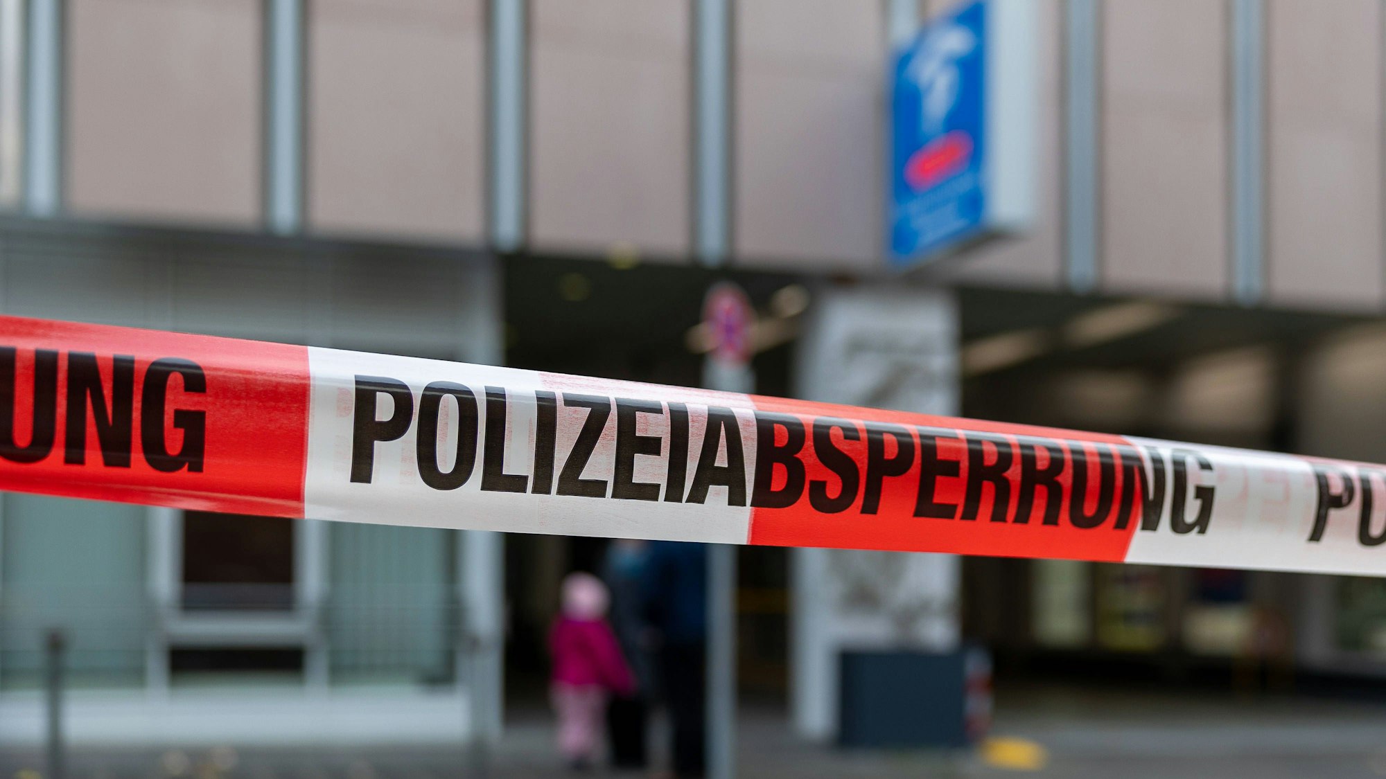 Nahaufnahme eines rot-weißen Polizeiabsperrbandes mit der Aufschrift "POLIZEIABSPERRUNG" und verschwommenem Hintergrund