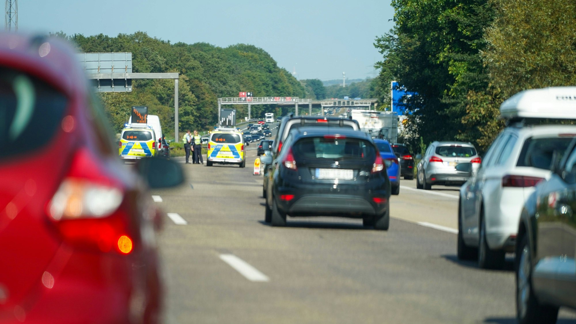 Verkehrsstau auf einer Autobahn mit einer Polizeikontrolle und Beamten auf der Fahrbahn
