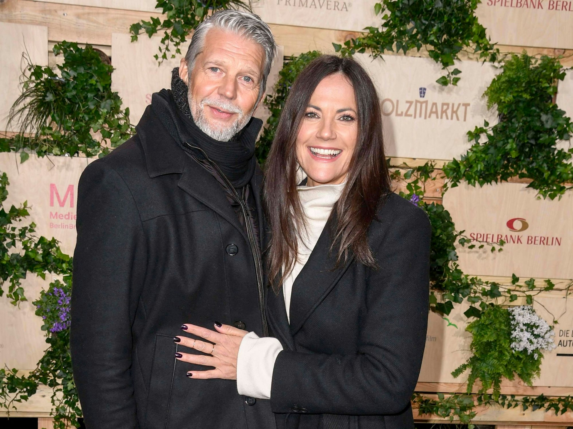 Ein Mann und eine Frau halten sich im Arm und lachen freundlich in die Kamera.