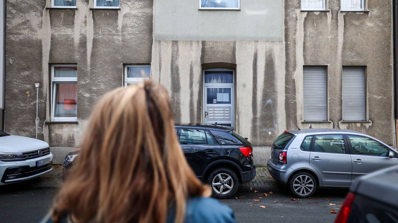 Eine Frau steht vor einem Mehrfamilienhaus. In einem Mehrfamilienhaus in Bochum ist ein zwölfjähriges Mädchen bei einem Polizeieinsatz durch Schüsse aus einer Dienstwaffe lebensgefährlich verletzt worden.