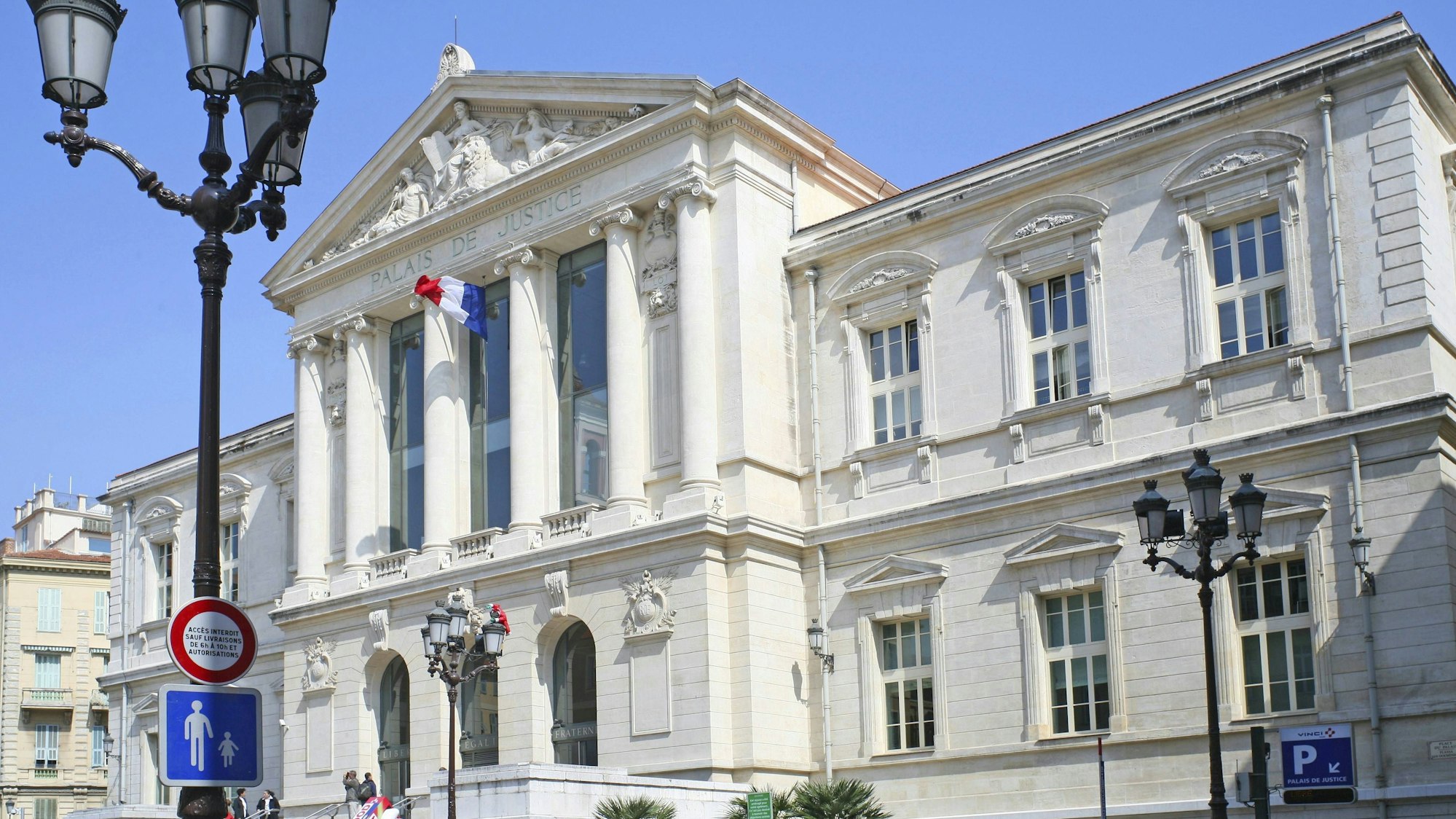 Großes klassisches Justizgebäude in Frankreich mit Säulen und Skulpturen unter blauem Himmel