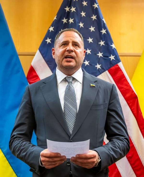 Andrij Jermak, Leiter des Präsidialamts der Ukraine, steht mit einem Zettel in der Hand vor der amerikanischen sowie ukrainischen Flagge.