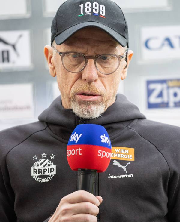 Peter Stöger mit Sky-Mikrofon unterm Kinn.