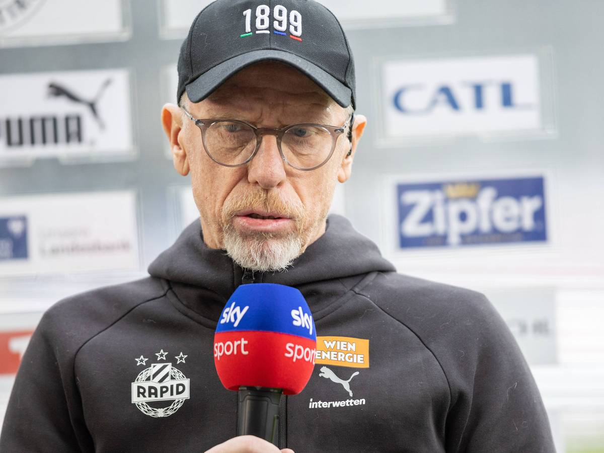 Peter Stöger mit Sky-Mikrofon unterm Kinn.