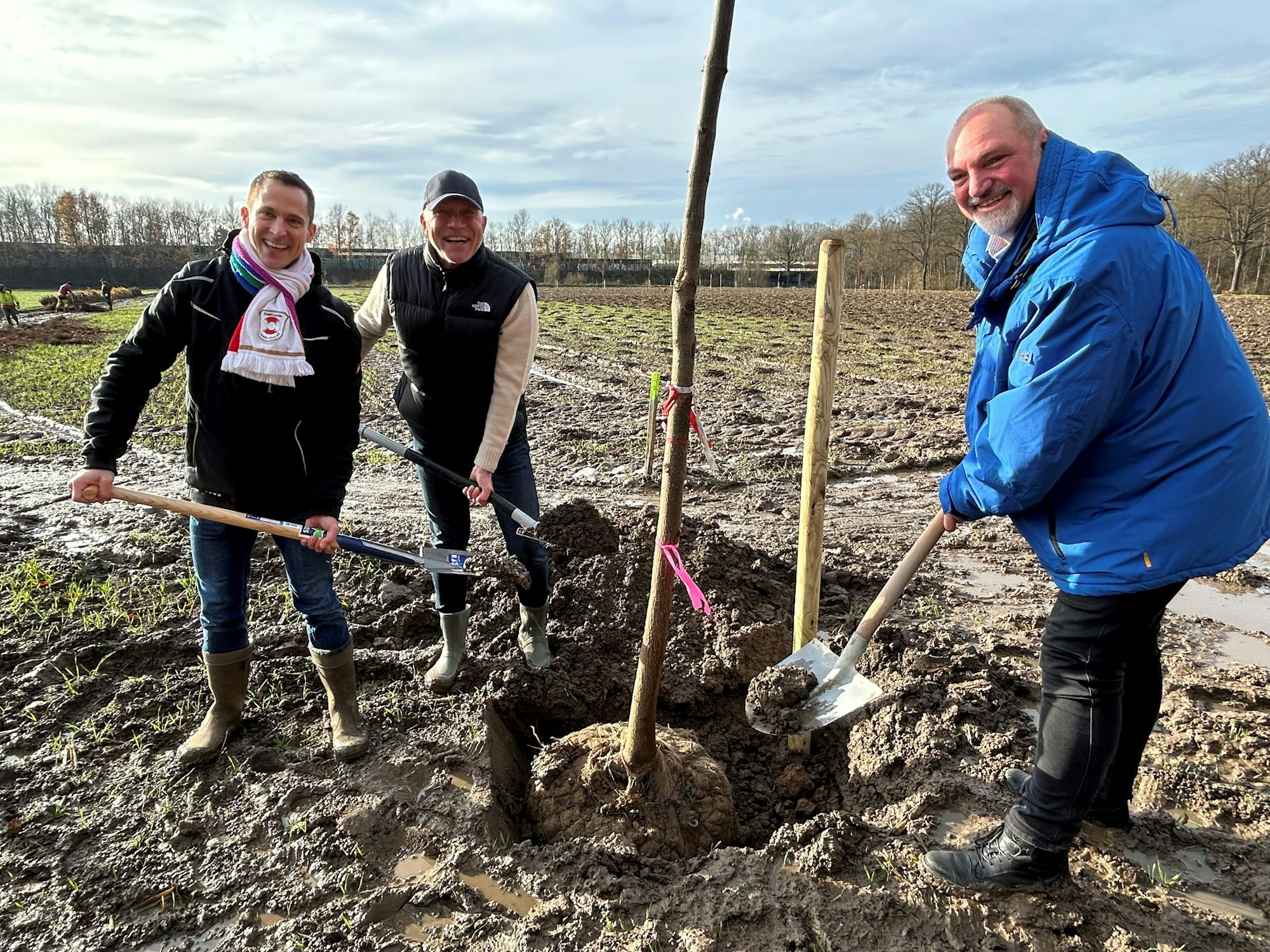 Hendrik Ermen, René Klöver und Michael Samm pflanzen Bäume ein.
