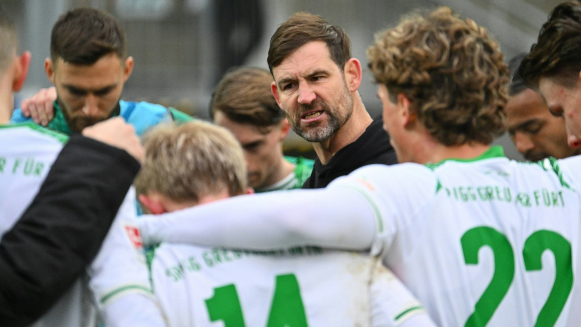 Thomas Kleine spricht leidenschaftlich mit Spielern von Greuther Fürth in einem engen Kreis.