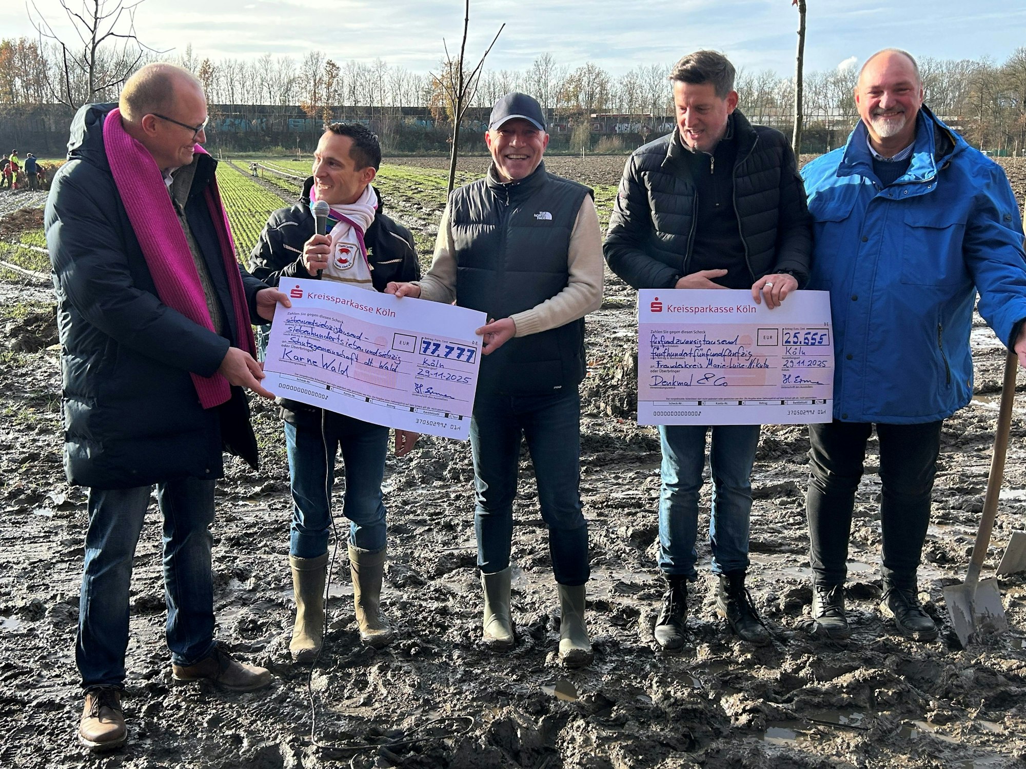 Das ehemalige Kölner Dreigestirn überreicht zwei Schecks.