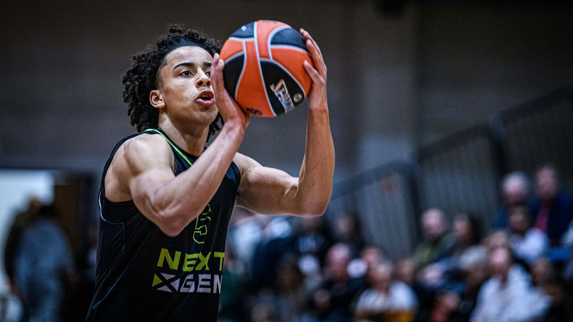 Davi Remagen, ein junger Basketballspieler, hält einen orange-schwarzen Ball bereit zum Wurf