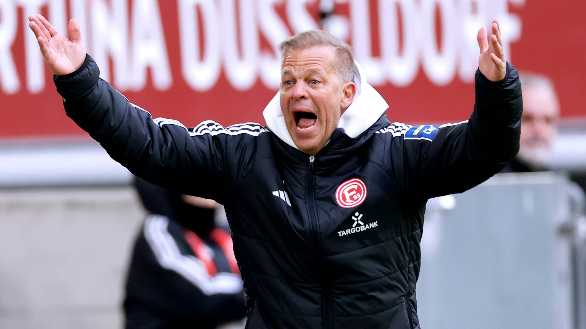 Markus Anfang ruft gestikulierend in Richtung des Spielfeldes.