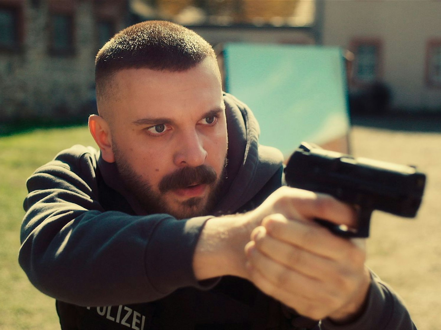 Hamza Kulina (Edin Hasanovic) sichert einen Hof, bei dem man nicht weiß, wer sich dort herumtreiben könnte. (Bild: HR/Sommerhaus/Tatiana Vdovenko)