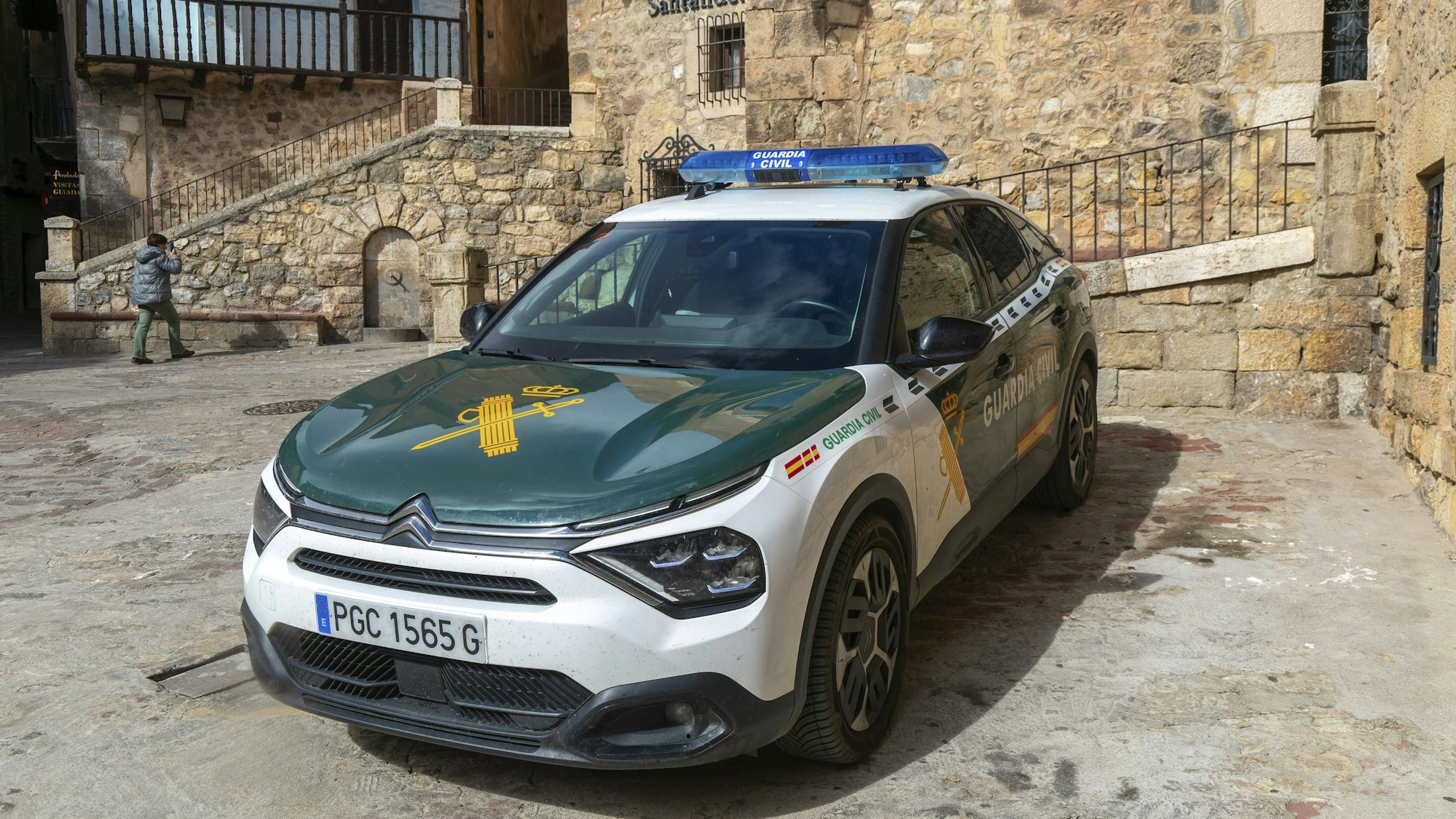 Weiß-grünes Guardia Civil Fahrzeug auf einem Platz vor alten Steingebäuden geparkt