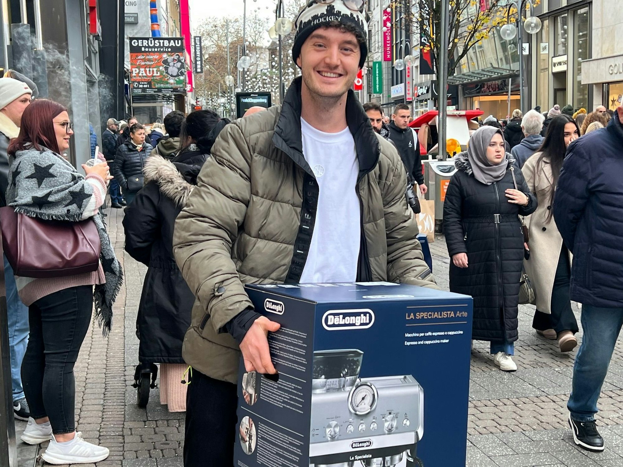 Jan N. sitzt mit einem großen Karton auf einer Bank in der Kölner Innenstadt.