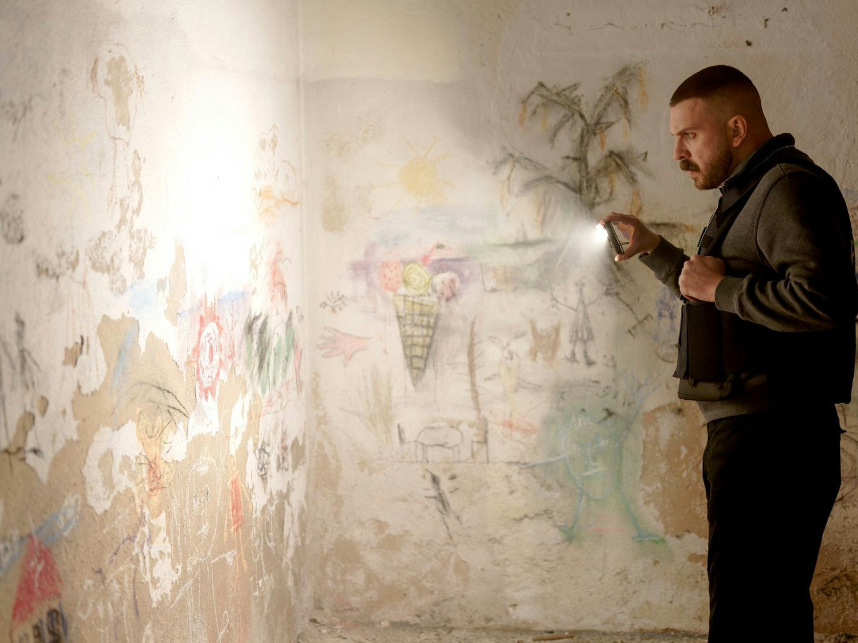 Was haben Kinderhände und -herzen hier geschaffen? Hamza Kulina (Edin Hasanovic) erkundet eine Wand. (Bild: HR/Sommerhaus/Tatiana Vdovenko)