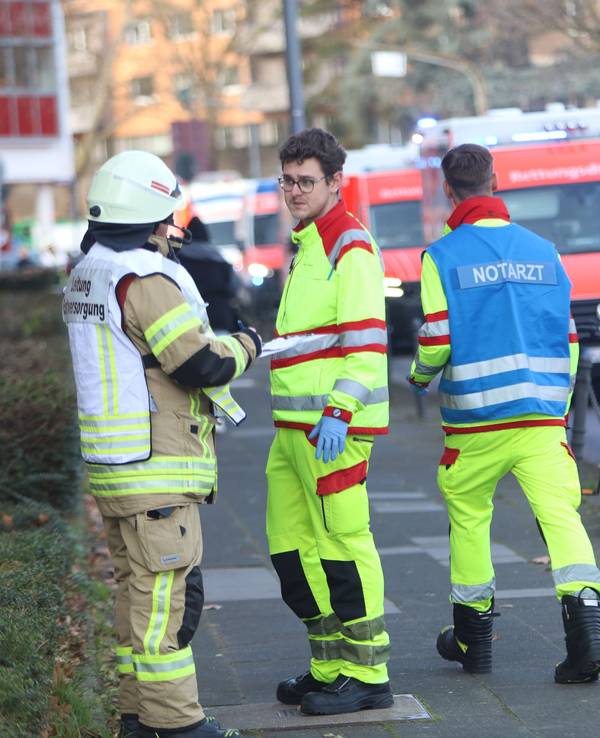 Einsatzkräfte, darunter ein Notarzt, sind im Einsatz. An der Straße stehen mehrere Einsatzfahrzeuge von Feuerwehr und Rettungsdiens.t