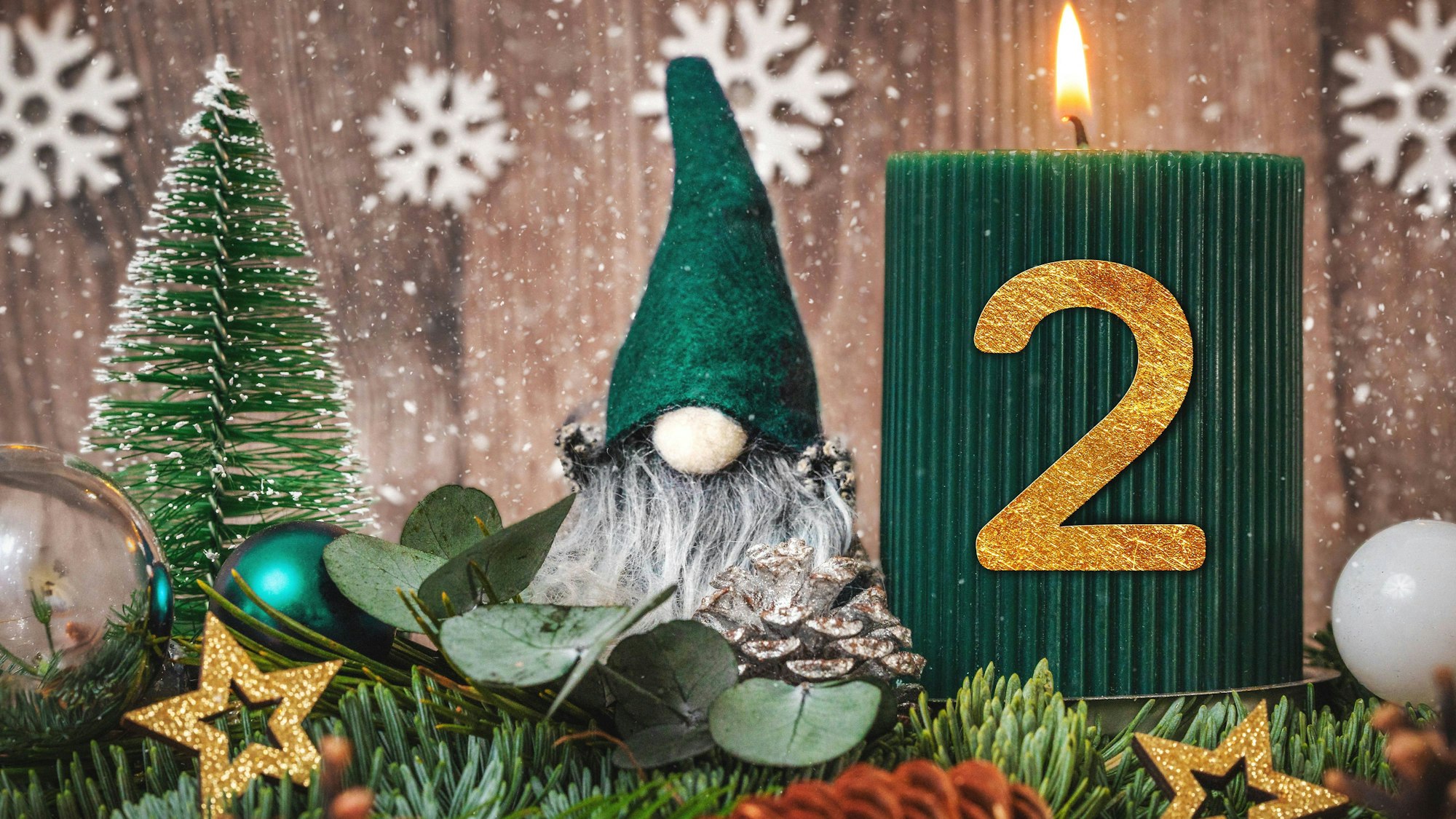Zweiter Advent: brennende Kerze mit goldener Zahl 2, Wichtel, Tannenbaum und Schnee