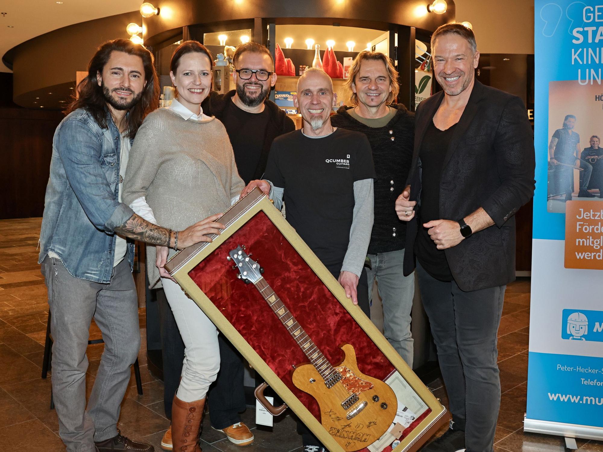Die Höhner übergeben die ersteigerte Gitarre.
