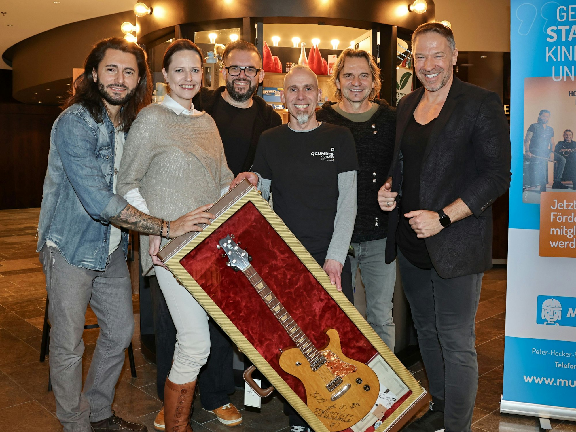 Die Höhner übergeben die ersteigerte Gitarre.