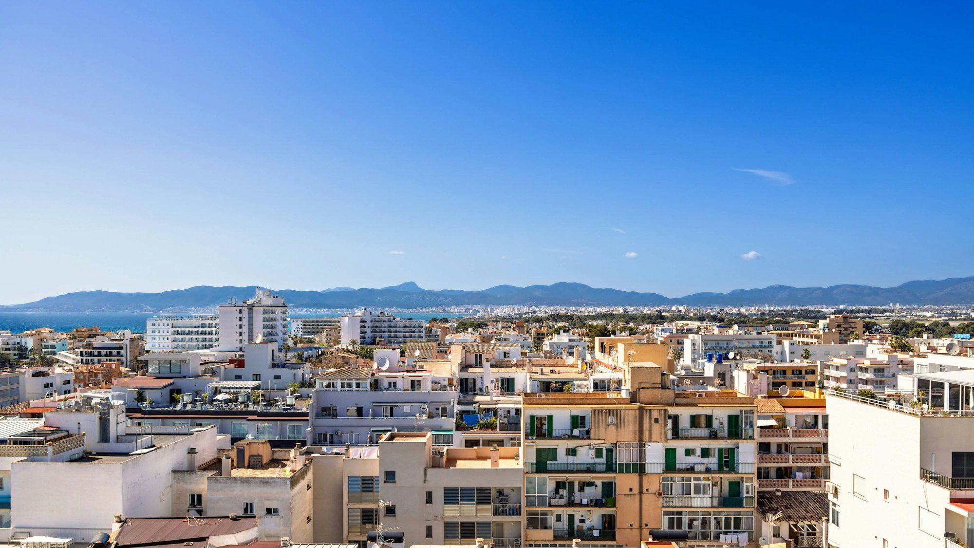 Luftaufnahme von Wohngebäuden auf Mallorca mit Blick auf das Meer und die Berge im Hintergrund