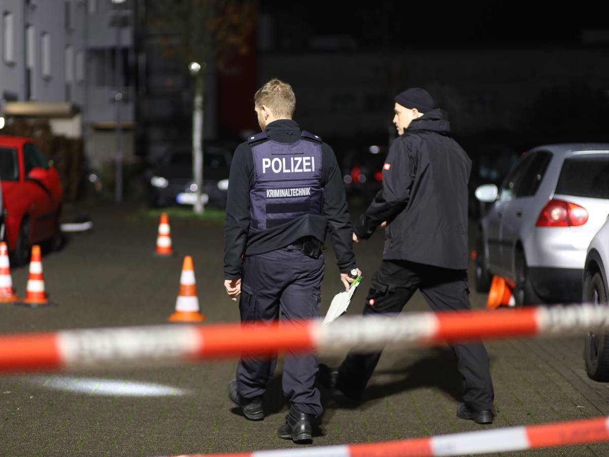 Zwei Einsatzkräfte sind an einem Tatort.