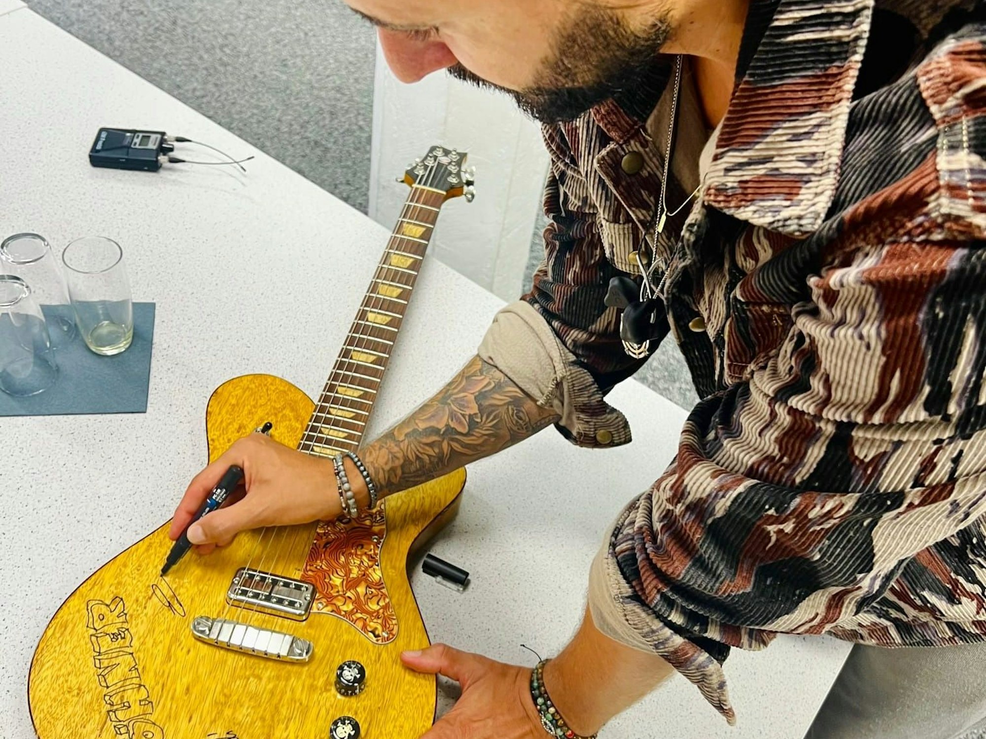 Edin Čolić unterschreibt auf seiner Gitarre.