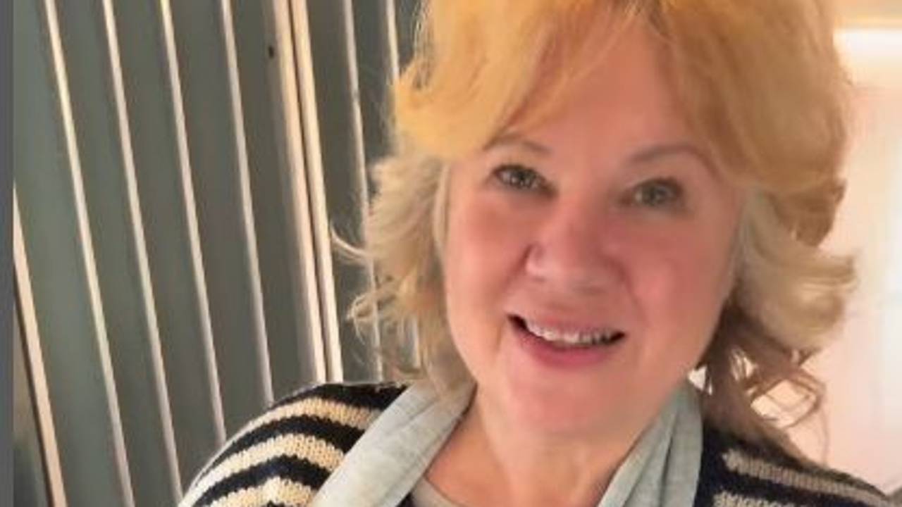 Eine Frau hat einen Hundewelpen in einer Tragetasche.