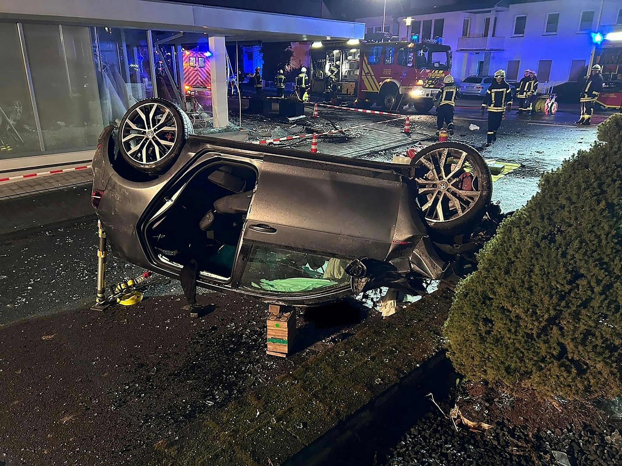 Ein Auto liegt in Olsberg auf dem Dach. Der Wagen kam von der Fahrbahn ab und fuhr durch das Schaufenster eines Modegeschäftes.