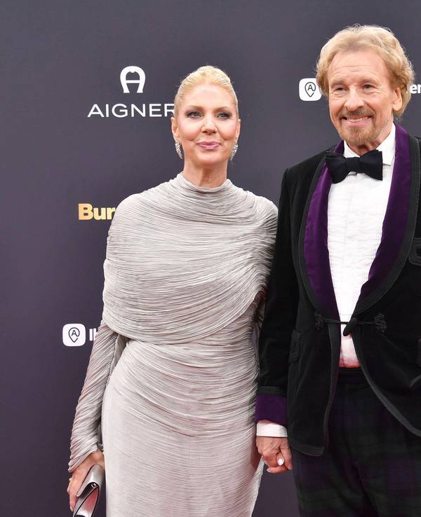 Thomas Gottschalk und Karina Mroß lächeln, Händchen haltend auf dem roten Teppich