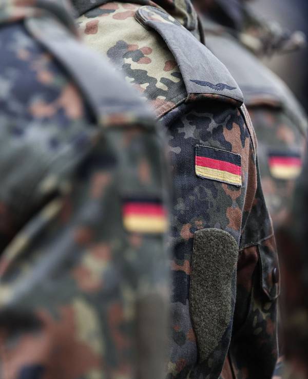 Soldaten tragen Deutschlandflaggen auf ihrer Uniform.