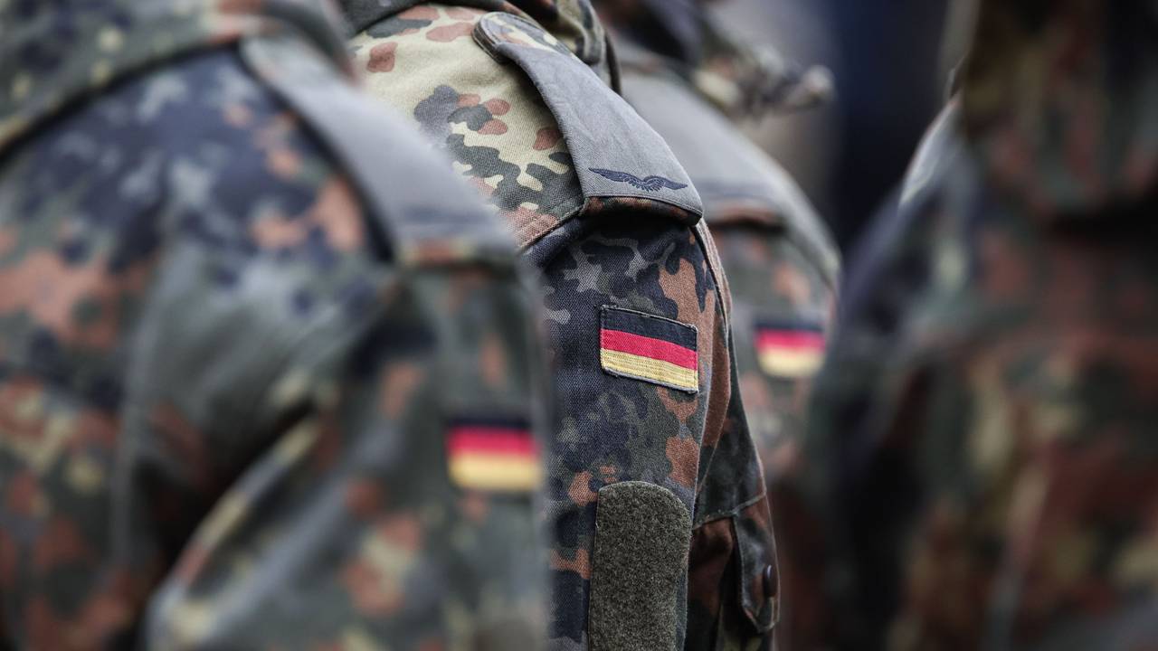 Soldaten tragen Deutschlandflaggen auf ihrer Uniform.