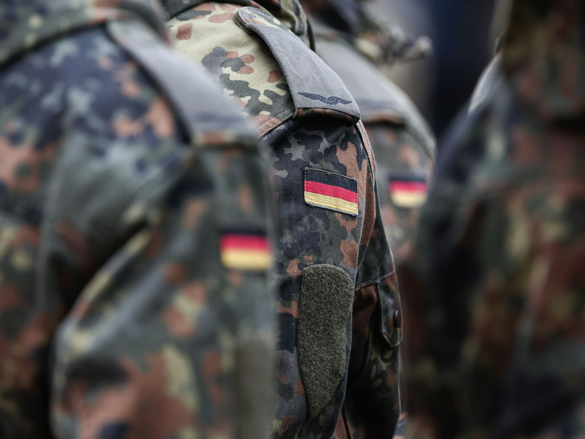 Soldaten tragen Deutschlandflaggen auf ihrer Uniform.