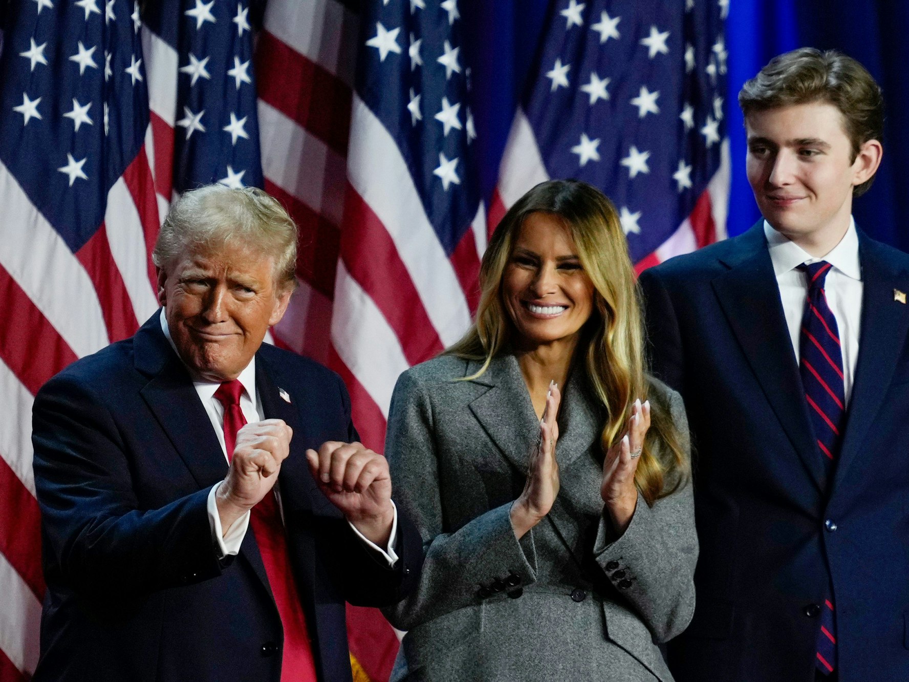 Der heutige US-Präsident Donald Trump (links) tanzt im November 2024 auf der Bühne mit der ehemaligen First Lady Melania Trump und Sohn Barron Trump.