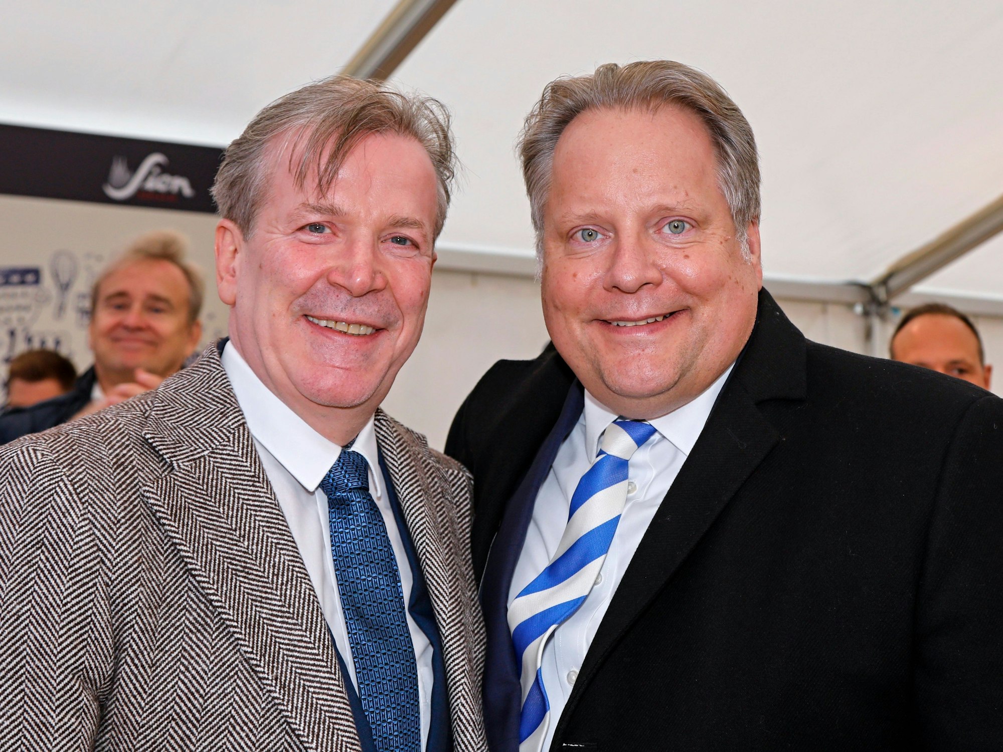 Zwei Männer grinsen in die Kamera.