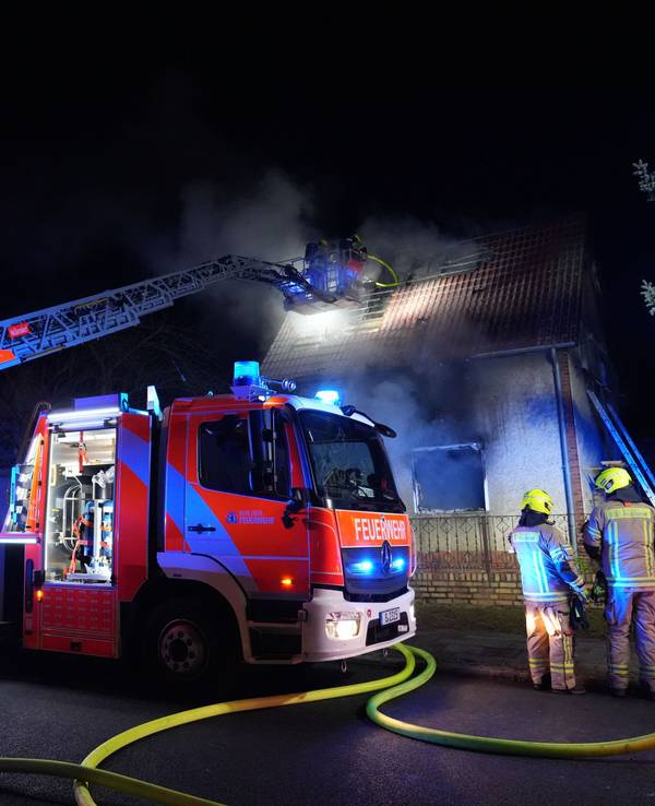 Feuerwehrleute sind im Einsatz bei einem Brand in einem Einfamilienhaus.