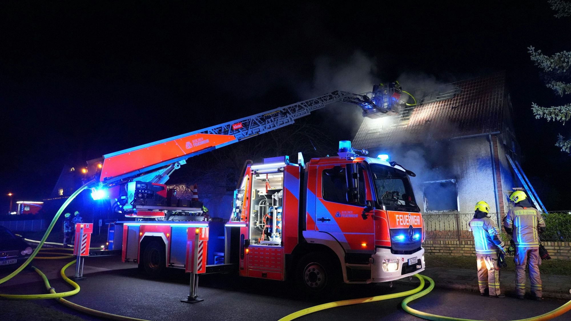 Feuerwehrleute sind im Einsatz bei einem Brand in einem Einfamilienhaus.