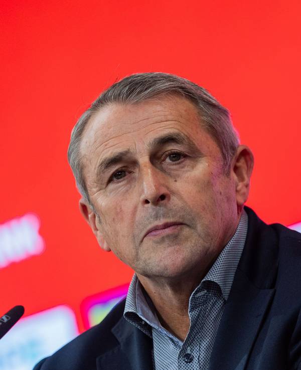 Klaus Allofs sitzt bei einer Pressekonferenz vor einem Mikrofon.